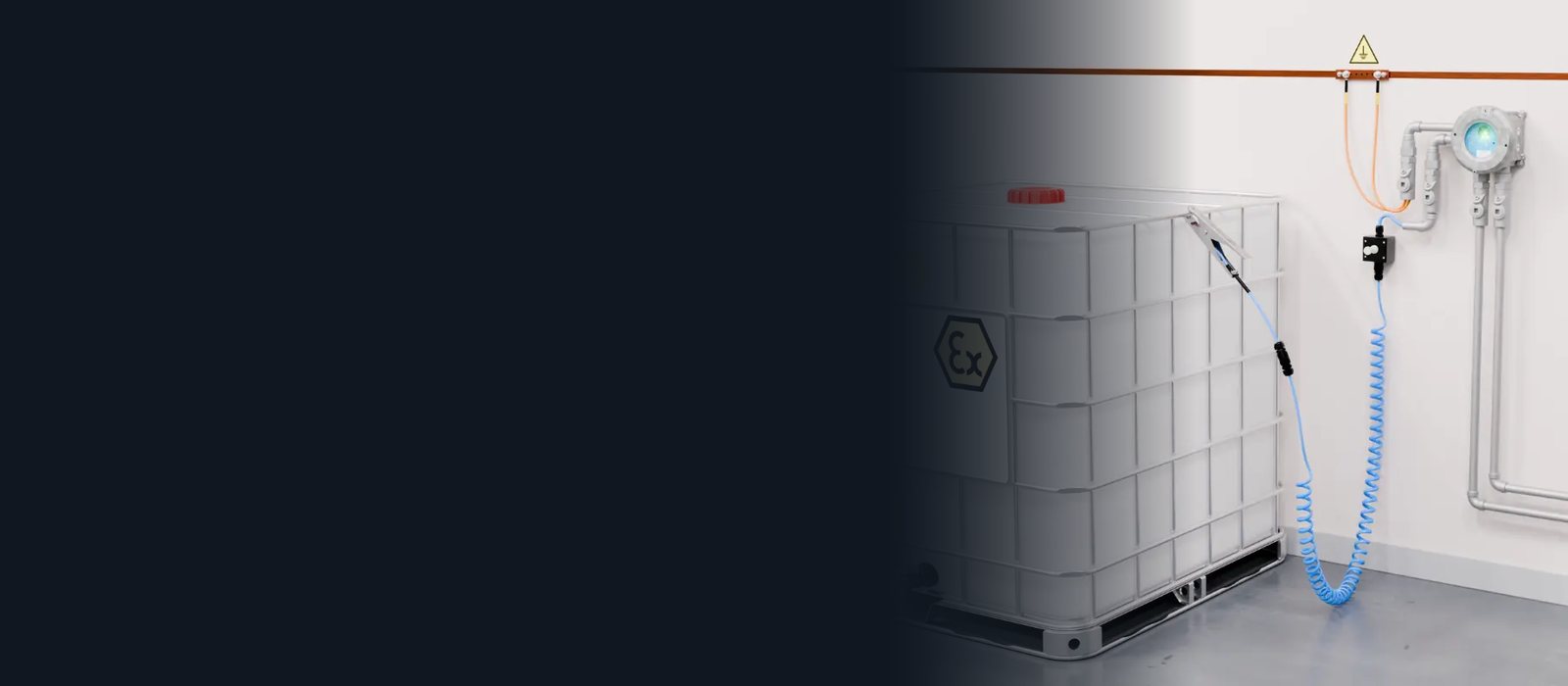 IBC 용기에 접지 클램프를 물리고 벽면 모니터가 접지 상태를 표시하는 장면 (Newson Gale Earth-Rite II PLUS)